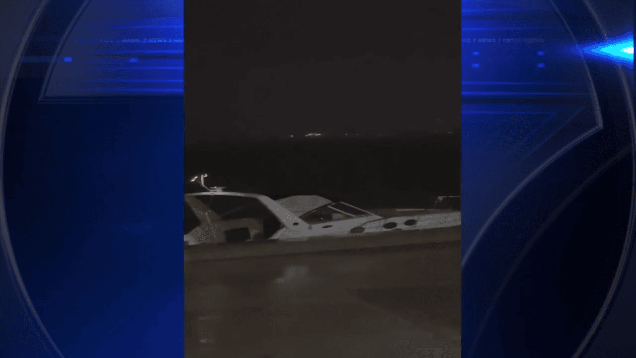 Boat washes up along seawall on Biscayne Bay due to strong winds; no one on board